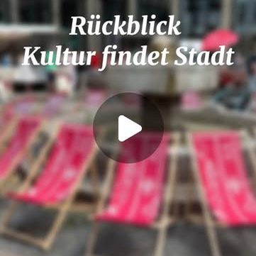 Rückblick Video 'Kultur findet Stadt' im Schwanenmarkt, Krefeld, mit rotem Teppich und Play-Button auf einem unscharfen Bild.